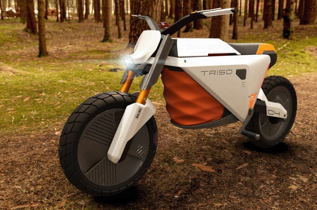 A motorcycle is parked in a wooded area.