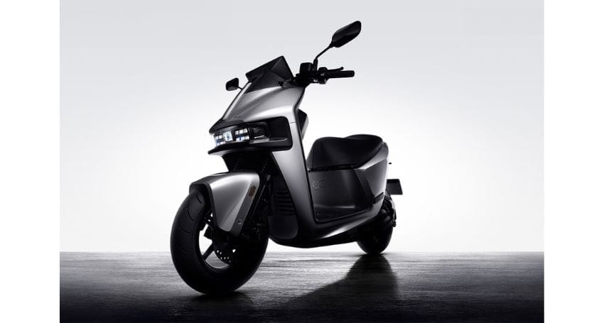 An electric scooter is parked in a dark room, optimized for efficient commuting.