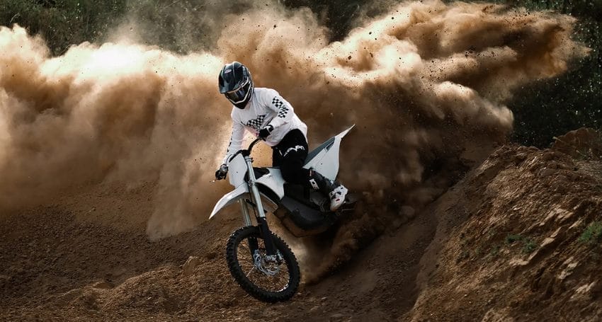 A person riding a dirt bike on a dirt track.