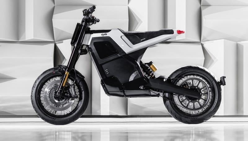 Modern electric motorcycle parked in front of a geometric patterned background, featuring a sleek black and white design focused on luxury.