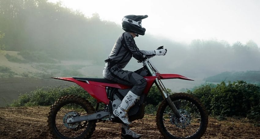 A person riding a dirt bike on a foggy day.