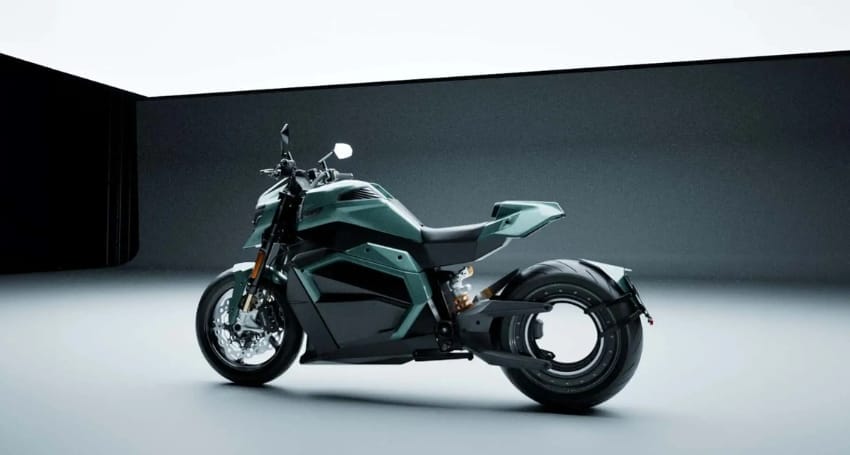 A green motorcycle sitting in a dark studio.