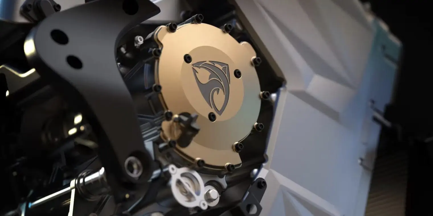 Close-up view of a mechanical component featuring a gold circular plate with a falcon-like logo in the center, surrounded by black and silver metal parts.