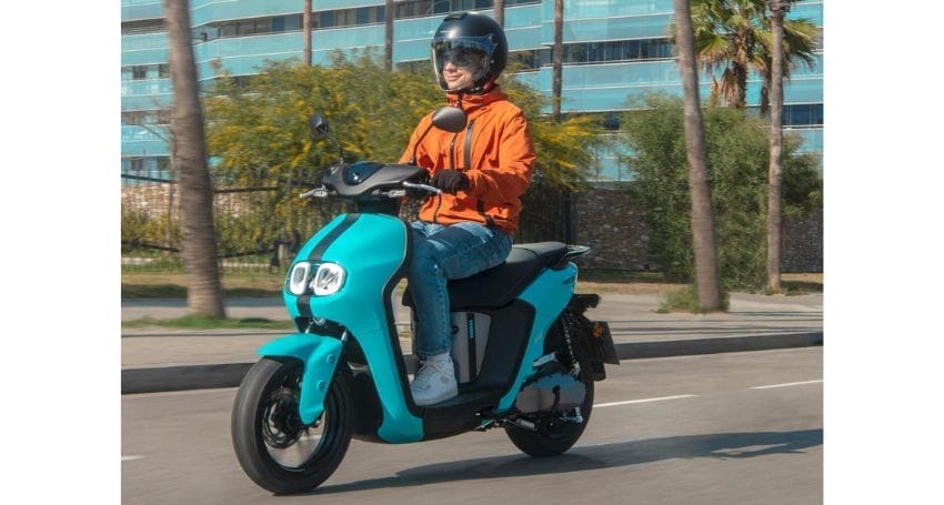 A person riding an electric scooter down a street during their daily commute.