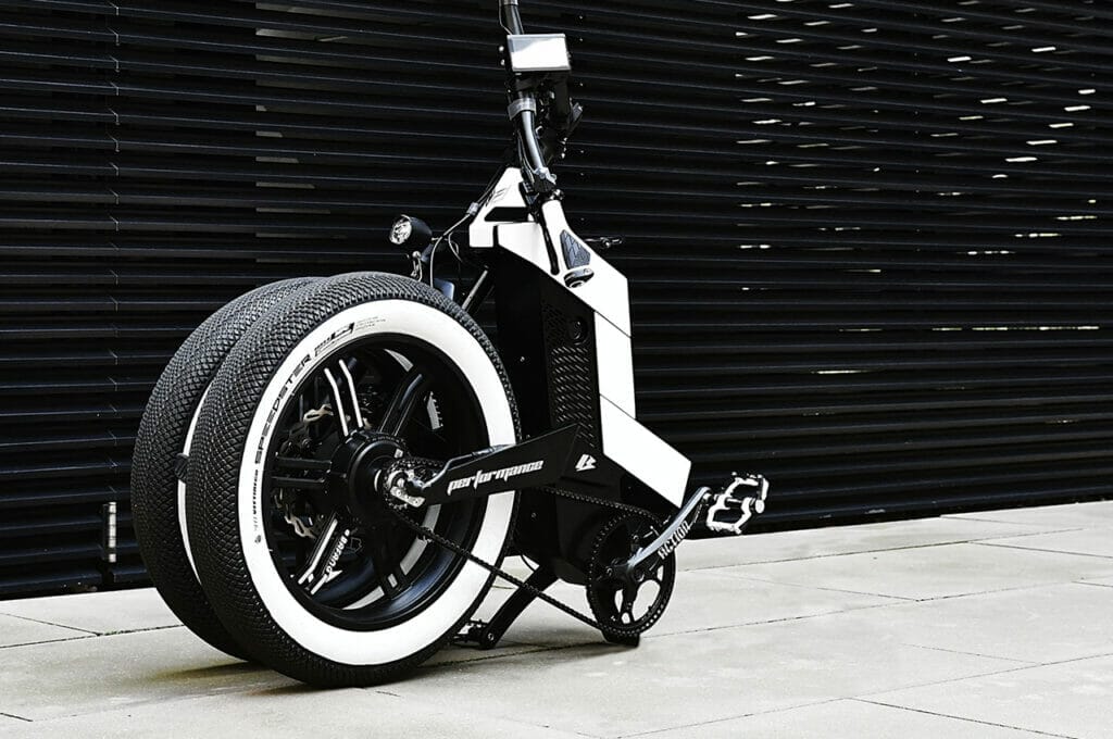 A black and white bicycle parked in front of a black door.