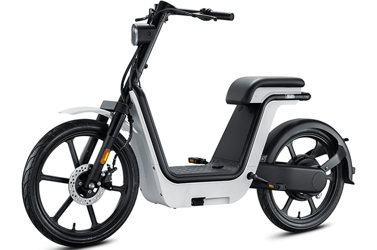 Black and white electric scooter with a minimalist design featuring a large cushioned seat, front and rear wheels, and a small platform for feet.