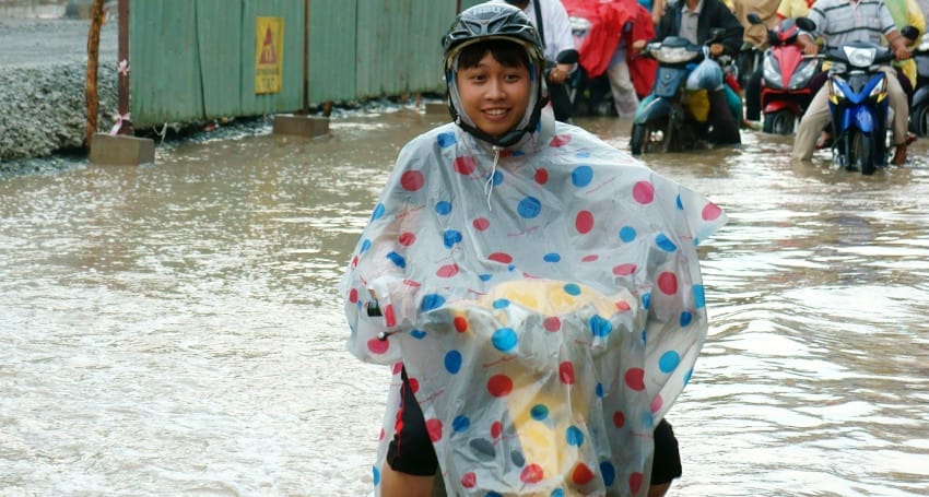 A person riding a motorcycle in a flooded area.