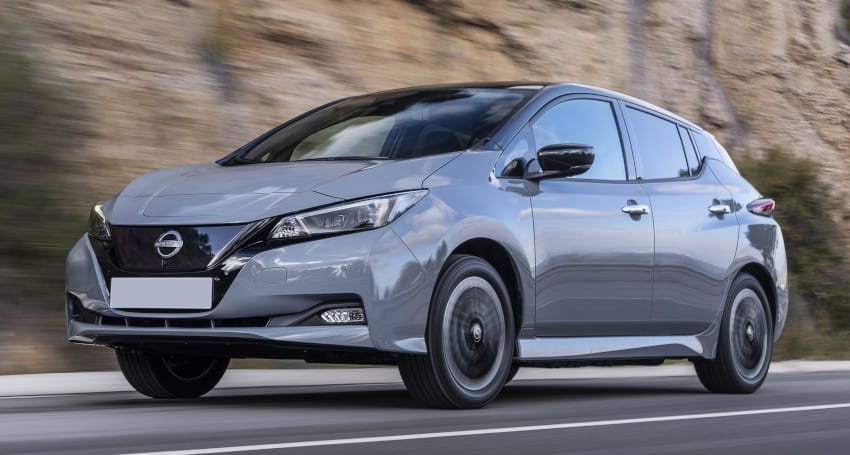 A silver nissan leaf driving on a road, showcasing its modern design and electric capabilities.