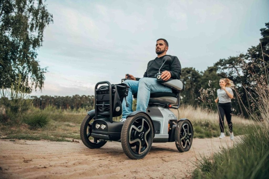 Introducing a man in a wheelchair navigating a dirt road.