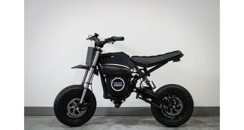 A black electric bike parked in front of a white wall.