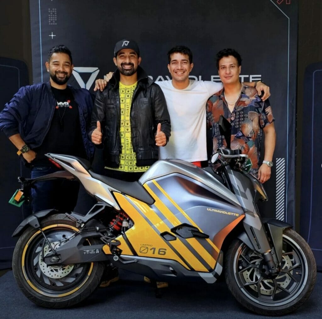 Four men posing with an Ultraviolette F77 motorcycle.