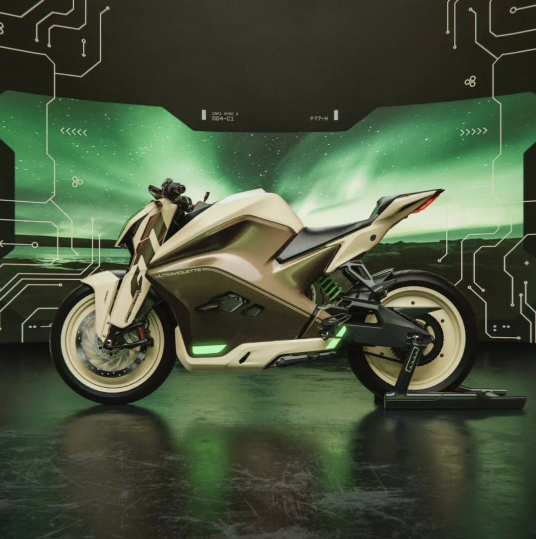 A futuristic motorcycle is displayed indoors against a backdrop of a digital green interface and abstract lines. The motorcycle has a sleek design with illuminated accents.