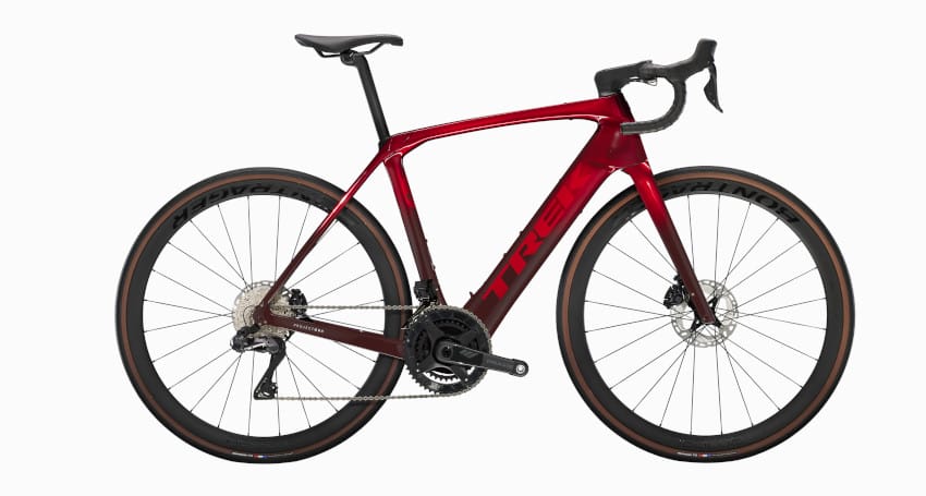 A red and black road bicycle with drop handlebars, a sleek frame, and thin tires on a white background.