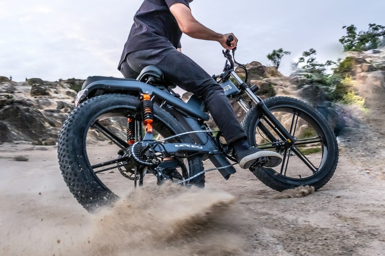 a man riding a motorcycle down a dirt road