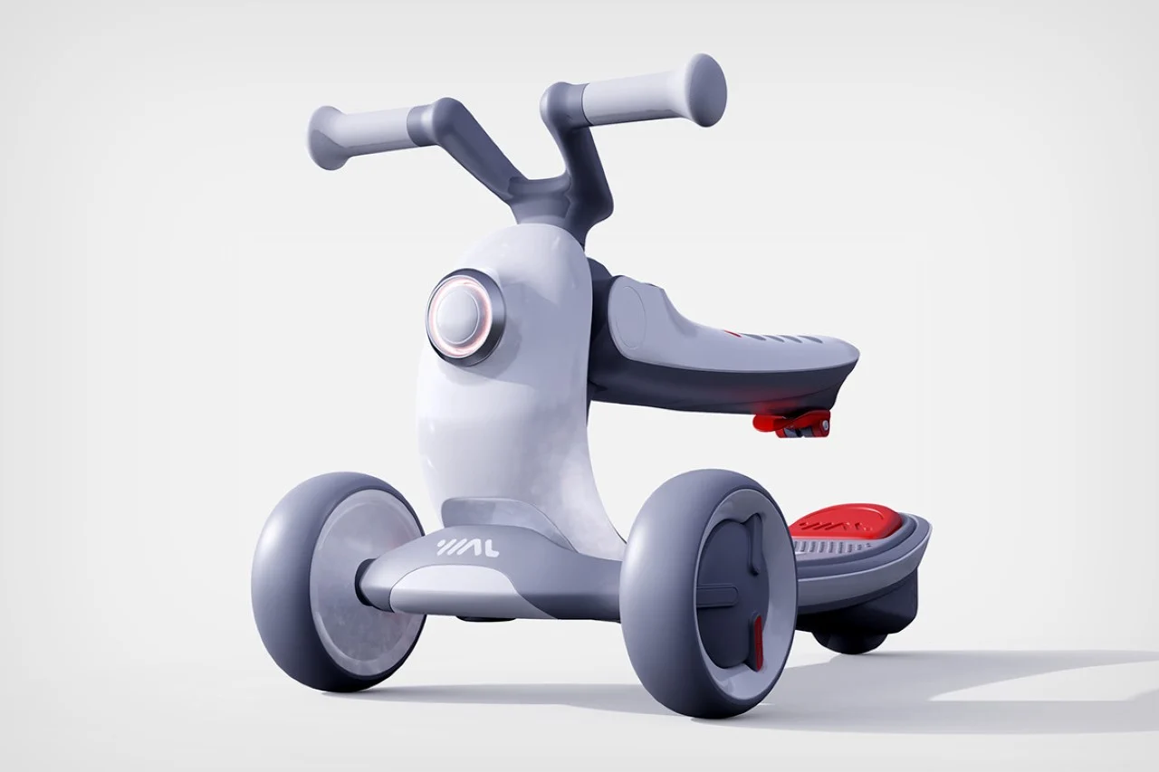 A small, grey and red tricycle with plastic handlebars and wheels, designed for young children.