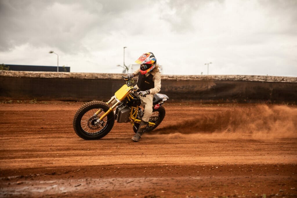 Trevor Motorcycles revolutionizing flat track racing with a person riding a dirt bike on a dirt track.