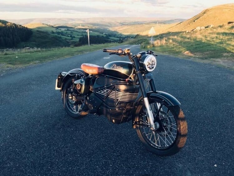 A black motorcycle parked on the side of a road, poised to be Royal Enfield's first electric launch by 2025.