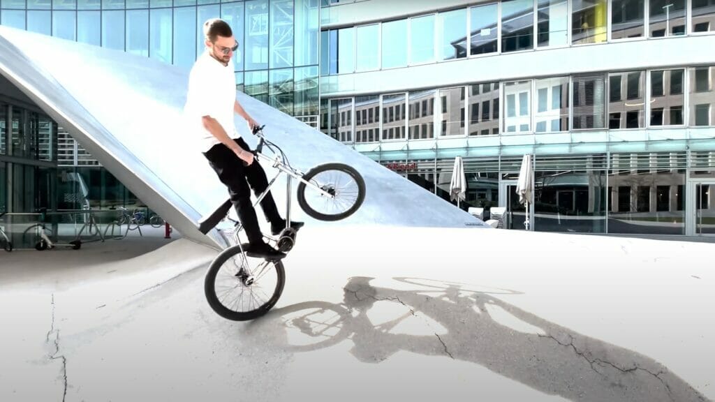 A man riding a bike in front of a building.