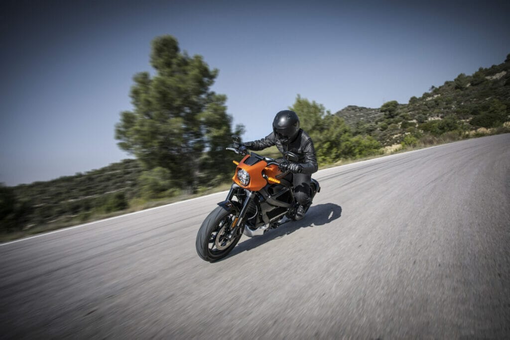 Person, orange motorcycle, road