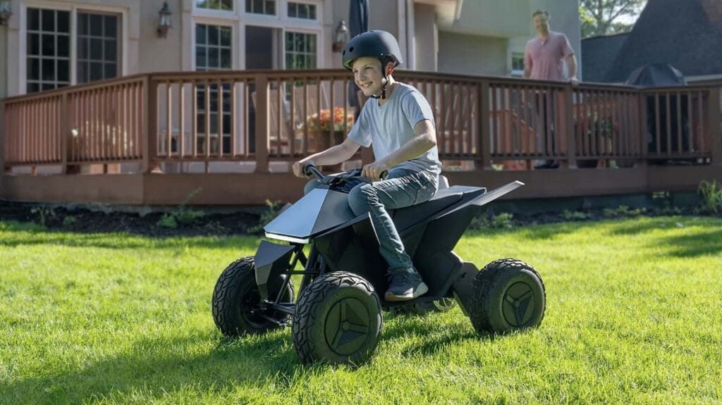 A boy riding a quad atv in the grass.